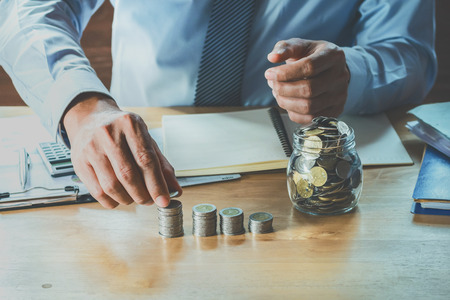 accountant calculate money coins on table in office. concept finance and accountingの写真素材
