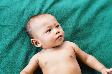 cute asian baby on the bedの写真素材