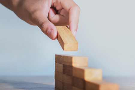 hand stack woods block step on table. business development concept