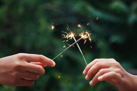 hand holding candle firework on green backgroundの写真素材