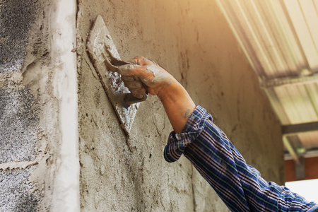 closeup hand of worker are plastering on wallの写真素材