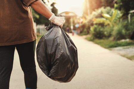 woman hand holding garbage bag for recycle putting in to trash