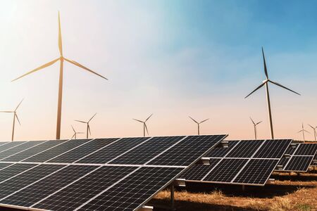 clean energy concept. solar panel with wind turbine and blue sky