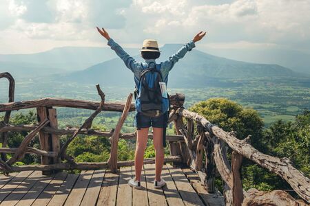 Woman traveler with backpack enjoying view and happy freedom at mountainsの写真素材