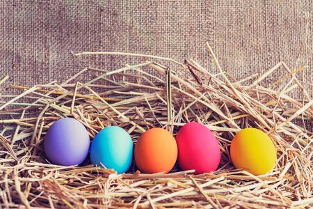 easter painted eggs in basket on fabric background