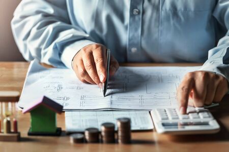 businessman working on desk office with using a calculator to calculate finance accounting conceptの写真素材