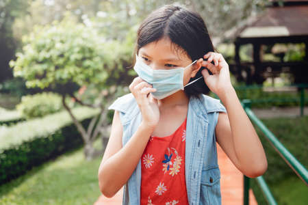 children wearing face protection in prevention for coronavirus during wlaking in parkの写真素材