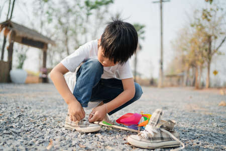 boy sitting in a park with shoelacesの写真素材