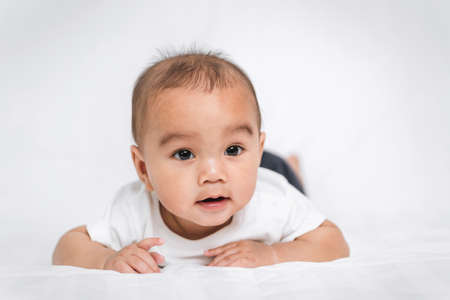 asian cute baby boy on white bed in roomの写真素材