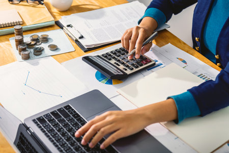 accounting concept. businesswoman working using calculator with money stack in officeの写真素材