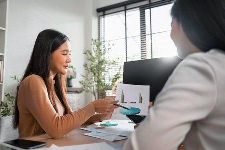 Two female accountants have a team meeting to summarize financial information in the officeの写真素材