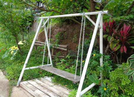 A Wooden Swing in the Tropical Gardenの写真素材