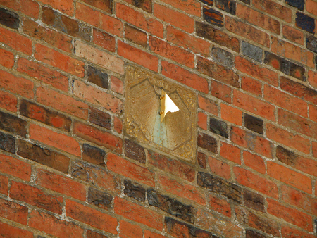 Sundial clock on the vintage bricked wall in Roskilde, Denmark