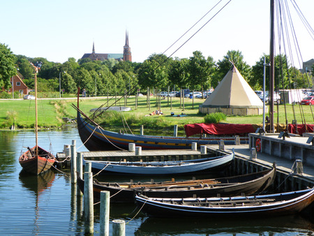 Moored Boats at the Pier and Roskilde City's Famous Landmark St. Luke Cathedral, Roskilde, Denmarkの写真素材