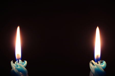 Pair of Burning Blue Candles Isolated On Black Backgroundの写真素材
