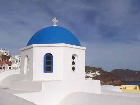 The unique pure white and vivid blue Greek islands style church at Oia village on Santorini island, Greeceの写真素材