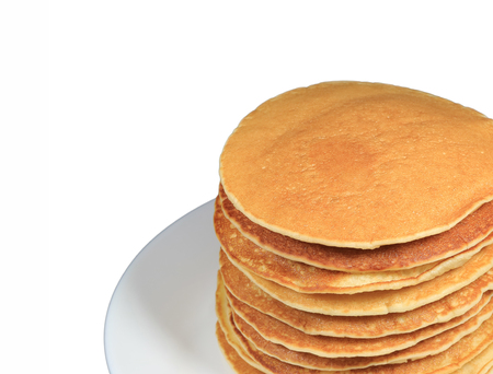 Stack of fresh homemade plain pancakes served on plate, isolated on white background with free space for text or designの写真素材