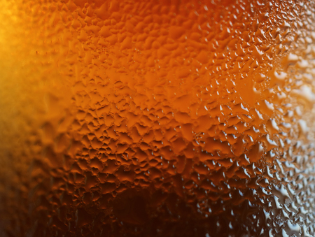 Macro shot of water drops texture on the deep orange color bottle, for abstract background with selective focusの写真素材
