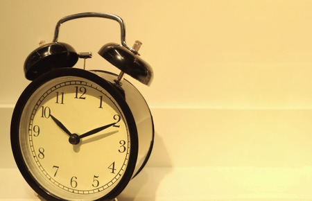 Retro alarm clock in the warm light, with free space for text and designの写真素材