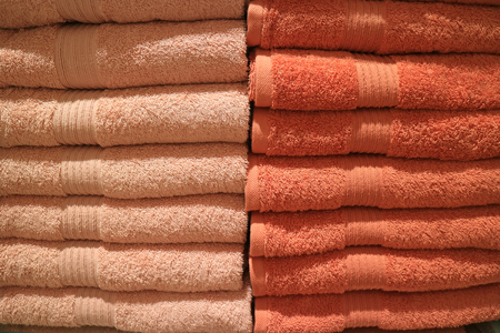 Stack of folded many tones of orange color bath towelsの写真素材