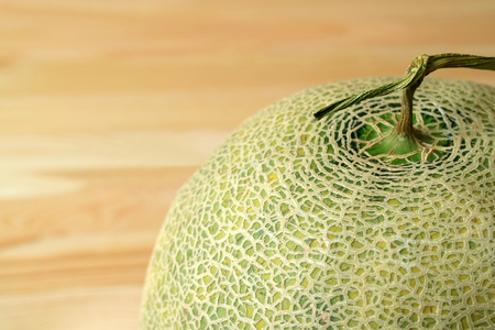 Closed up unique pattern of Cantaloupe Melon's peel with stem, blurred background and free space for text and designの写真素材