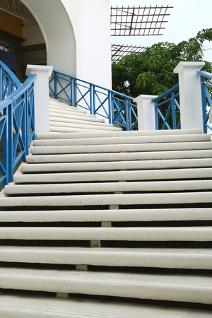 Vertical photo of white outdoors staircase with blue railing leads to the upstairsの写真素材