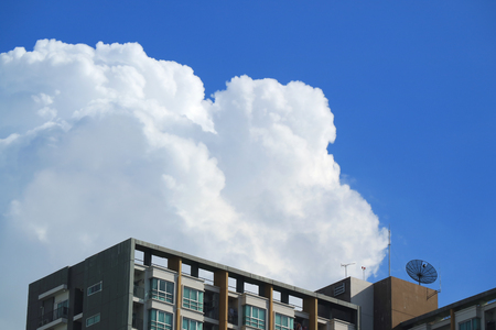 Pure white fluffy puffy cumulus clouds on vivid blue sky over the high buildings in Bangkok, Thailandの写真素材