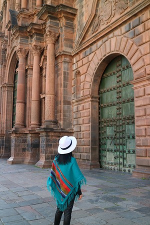 Female standing in front of the gorgeous door of Cusco Cathedral, Cusco, Peru, South America