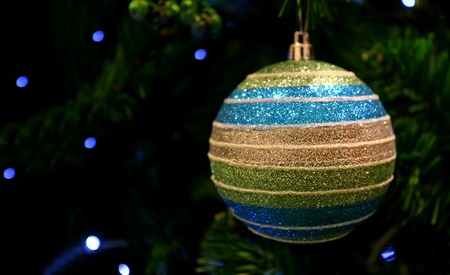 Multi Color Ball Shaped Glitter Ornament Hanging on the Sparkling Christmas Treeの写真素材