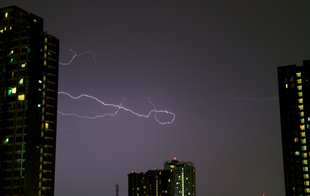 The Real Lightning Flashing on Night Sky over the High Buildings