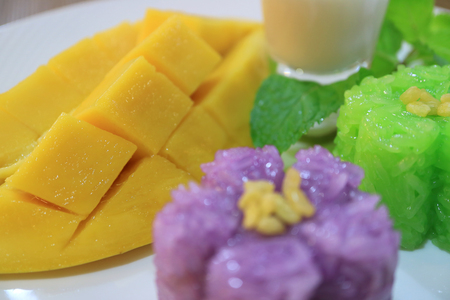 Closed Up Fresh Ripe Mango with Blurry Pea Flowers Sticky Rice in Foregroundの写真素材