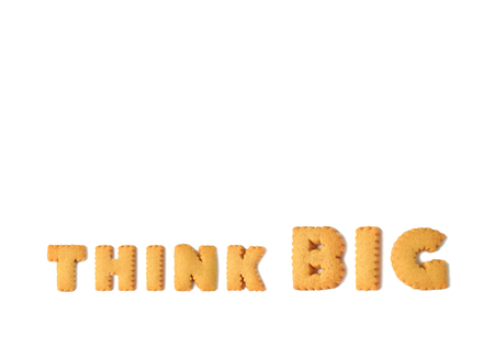 The word THINK BIG spelled with alphabet shaped cookies isolated on white backgroundの写真素材