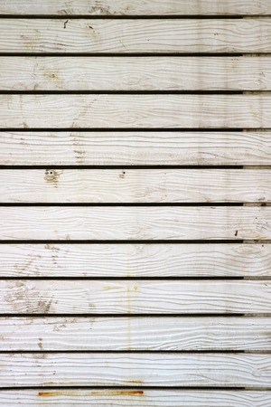 Vertical image of white colored wooden plank wall of an old building
