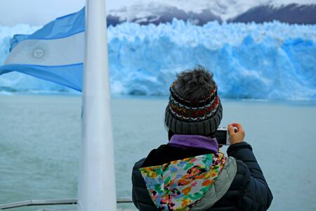 Female Tourist taking Photos of the Awesome Glacier Wall