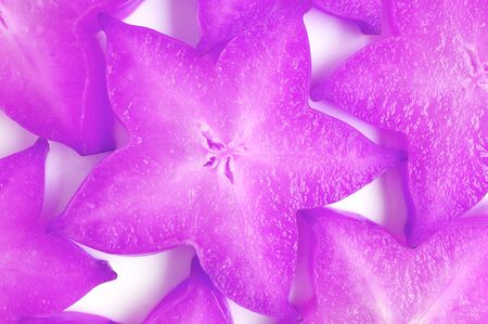 Top View of Sliced Fresh Star Fruits in Surreal Pop Art Styled Purple Colored for Backgroundの写真素材