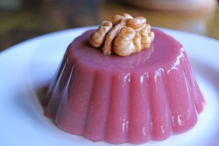 Closeup Pelamushi Topped with Walnut, Georgian National Sweets Served on White Plateの写真素材