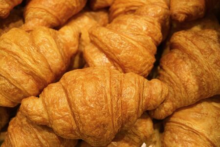 Pile of fresh baked croissant pastries for sale in the bakery