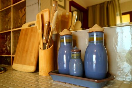 Seasoning bottles and wooden utensils on the kitchen counterの写真素材