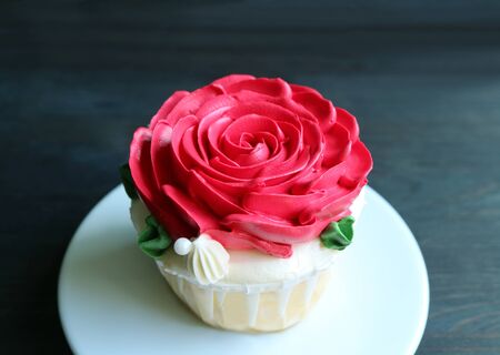 Closeup gorgeous cupcake decorated with red rose shaped whipped cream with copy spaceの写真素材