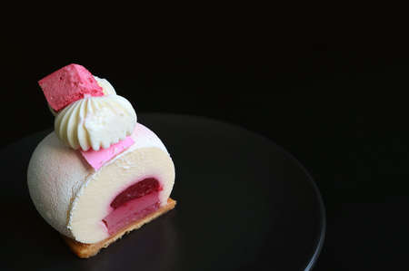 Slice of Strawberry Jelly Vanilla Mousse Cake on Black Plate with Copy Space on Black Background