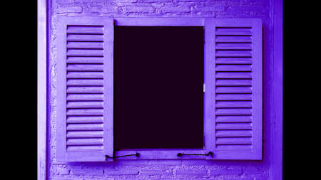 Vivid purple colored wooden window with shutters on brick wall with copy spaceの写真素材