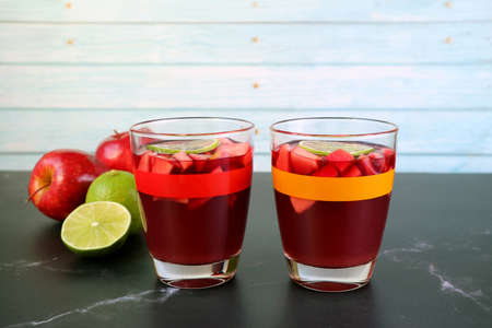 Two Glasses of Red Wine Sangria on the Table with Blurry Apples and Limes in Background