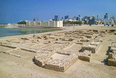 Remains of Qal'at al-Bahrain or Bahrain Fort Structure with Its Museum and Manama Modern Cityscape in the Backdrop, Manama, Bahrainのeditorial素材