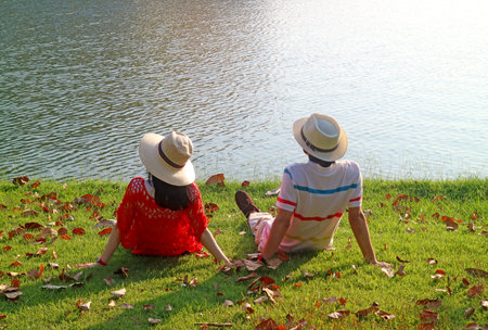 Couple in straw hat relaxing together on the lakesideの写真素材