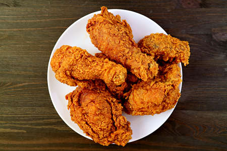 Plate of Delectable Golden Brown Crispy Fried Chickens on Wooden Backgroundの写真素材