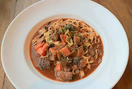 Plate of Delectable Homemade Slow Cooked Beef Stew with Fettuccineの写真素材