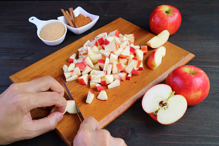 Hand dicing fresh apples on cutting board for making apple compoteの写真素材