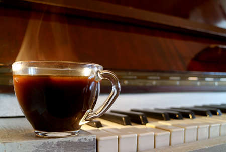 Closeup a Cup of Hot Coffee with Smoke Isolated on the Pianoの写真素材