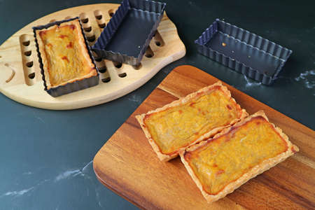 Two of Fresh Baked Pumpkin Cake Bars on the Wooden Breadboard with Another in the Backdropの写真素材