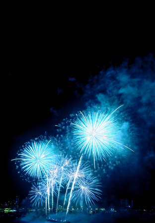 Fantastic vibrant blue fireworks splashing in the night sky over the harborの写真素材